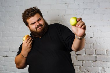 hamburger ve yeşil elma arasında seçim yapma adam portresi
