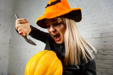 Kabak ve kaşık tutan turuncu şapka Halloween cadı