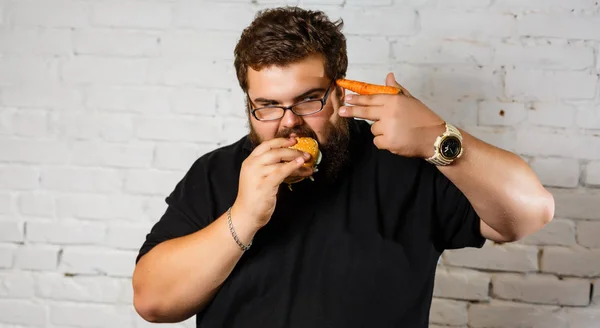Kövér Ember Mohón Eszik Hamburgert Fehér Téglafal Háttér — Stock Fotó