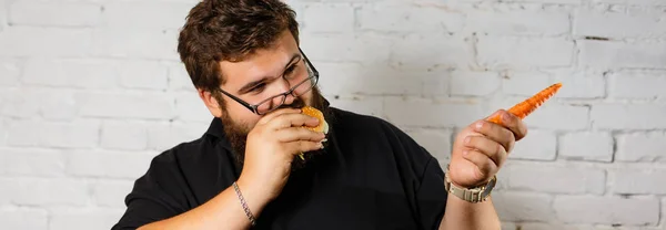 stock image Fat Man Greedily Eating Hamburger on white brick wall background