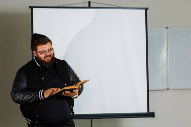 Erkek öğretmen sınıf oda ayakta kitap okuma