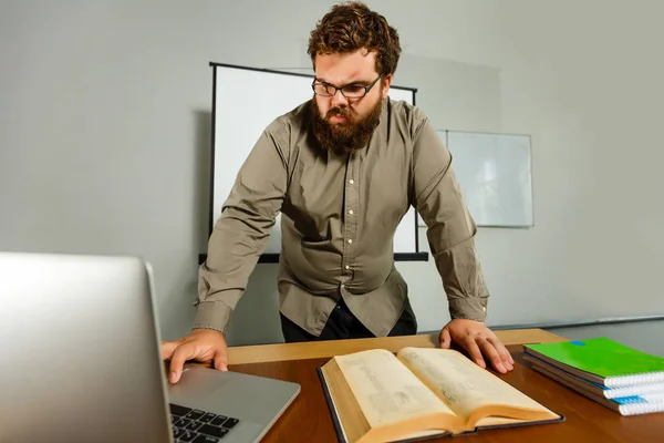 Nachdenklicher Europäischer Geschäftsmann Liest Buch Schreibtisch Mit Laptop — Stockfoto