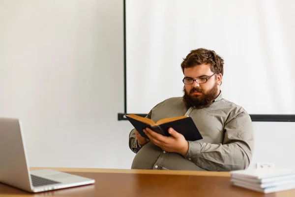 Nachdenklicher Europäischer Geschäftsmann Liest Buch Schreibtisch Mit Laptop — Stockfoto