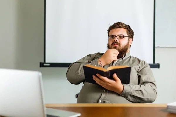 Nachdenklicher Europäischer Geschäftsmann Liest Buch Schreibtisch Mit Laptop — Stockfoto