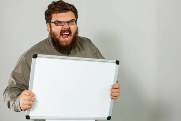bearded teacher standing on light studio background with blank board