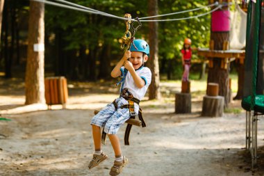 küçük çocuk ip parkta eğleniyor