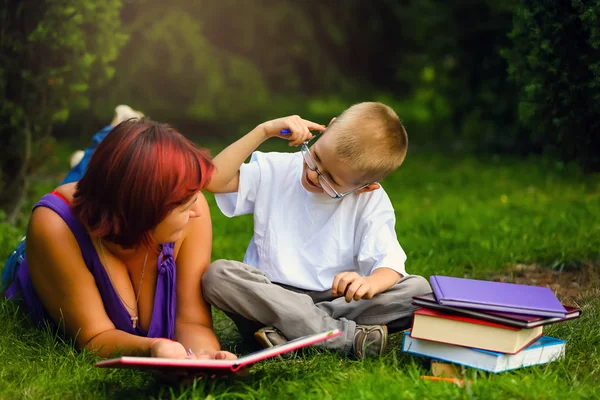 Junge Mutter Und Sohn Liegen Mit Buch Auf Der Wiese — Stockfoto