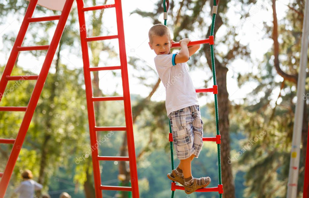 little boy playing on monkey bars in autumn, kids sport