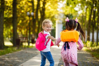 El ele tutuşarak okula iki güzel küçük kız. Okula dönüş