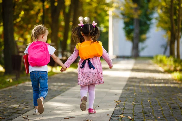 Δύο Όμορφα Μικρά Κορίτσια Που Πηγαίνουν Στο Σχολείο Κρατώντας Χέρια — Φωτογραφία Αρχείου