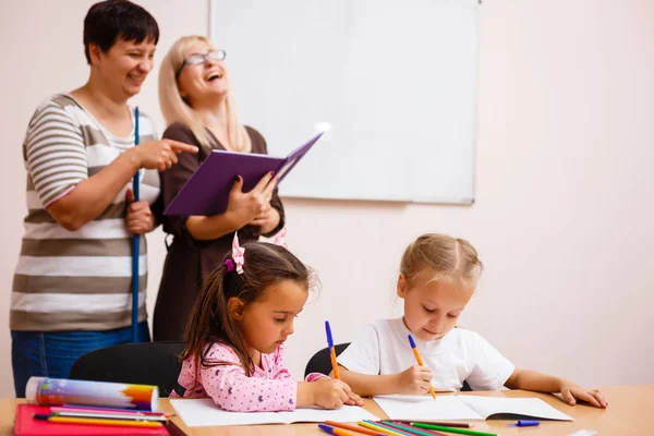 Dos Profesores Trabajando Clase Con Sus Pequeños Alumnos Sentados Escritorio — Foto de Stock