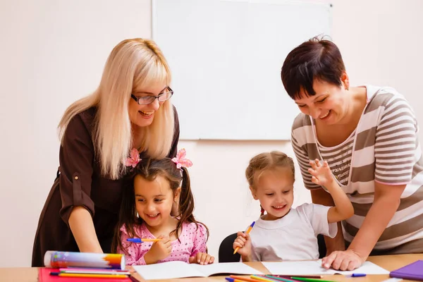 Dos Profesores Trabajando Clase Con Sus Pequeños Alumnos Sentados Escritorio — Foto de Stock