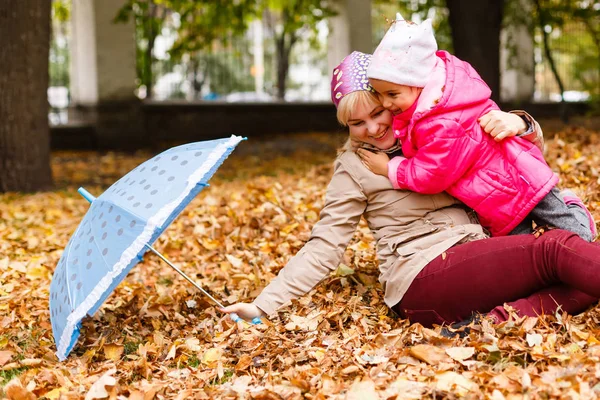 mutlu küçük kız annesi ile sonbaharda oynamaktan Şehir Parkı üzerinde bırakır