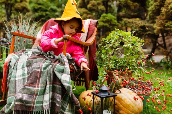 Rozkošná Holčička Nosit Kostým Halloween Baví Sedět Křesle Zařízené Zahradě — Stock fotografie