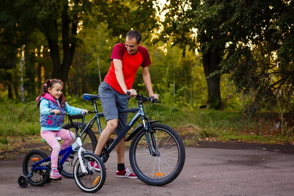 Gelukkig Jonge Vader Zijn Dochtertje Paardrijden Fietsen Groen Park — Stockfoto