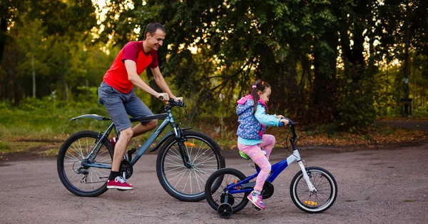 Счастливый Молодой Отец Маленькая Дочь Катаются Велосипедах Зеленом Парке — стоковое фото
