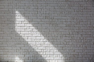 Güneş beyaz beton duvarın üzerine atiyor, güneşlik gölgesi