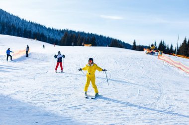 Sarı kış tulum sürme kadında karlı dağlarda kayaklar 