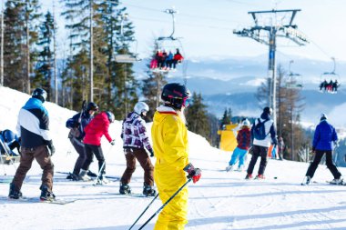 Sarı kış tulum sürme kadında karlı dağlarda kayaklar 