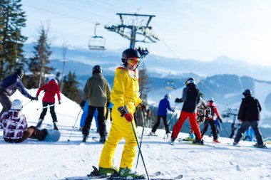 Sarı kış tulum sürme kadında karlı dağlarda kayaklar 