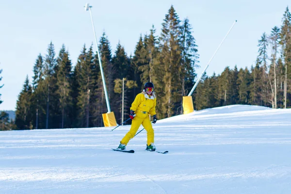 妇女在黄色冬天连身裤骑马滑雪板在雪山 — 图库照片