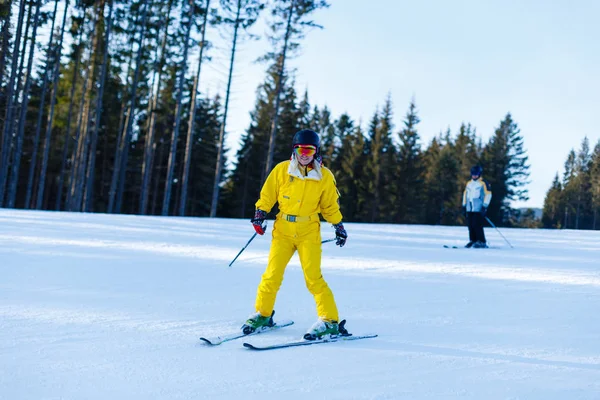 妇女在黄色冬天连身裤骑马滑雪板在雪山 — 图库照片
