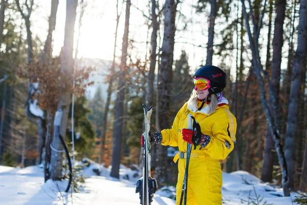 在雪林与滑雪板摆姿势的年轻妇女冬天黄色服装 — 图库照片