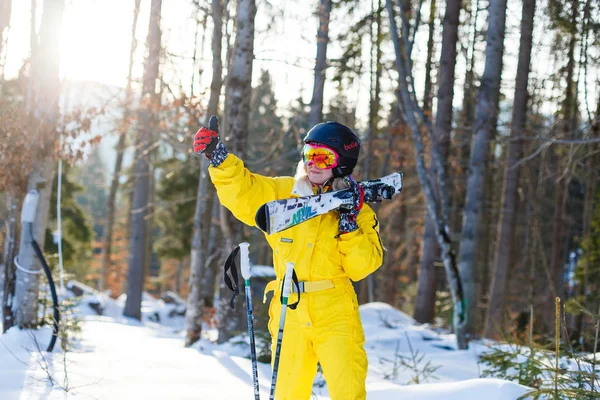 在雪林与滑雪板摆姿势的年轻妇女冬天黄色服装 — 图库照片