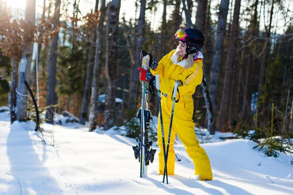 雪に覆われた森でスキーとポーズ黄色冬衣装の若い女性 — ストック写真