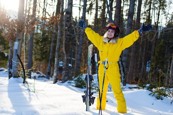 雪に覆われた森でスキーとポーズ黄色冬衣装の若い女性 — ストック写真