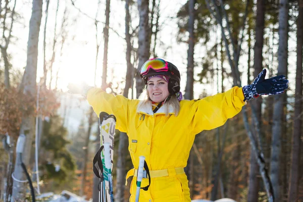 雪に覆われた森でスキーとポーズ黄色冬衣装の若い女性 — ストック写真