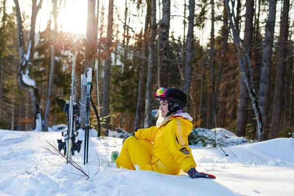 穿着黄色滑雪服的快乐女人躺在白雪上 — 图库照片