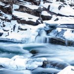 Vista panorámica del río rocoso salvaje en bosques congelados