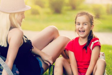 Genç anne kızıyla bahar parkında vakit geçiriyor.