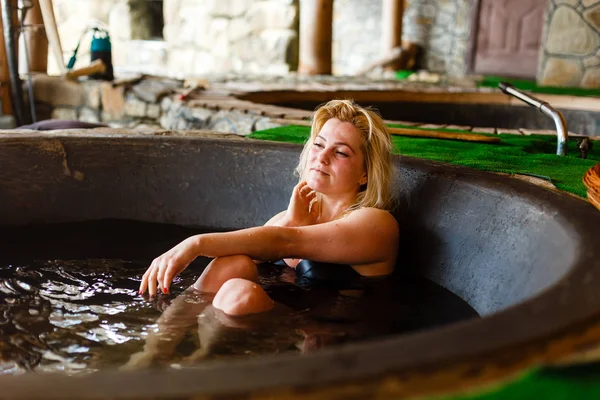 Adult woman resting in hot tube in cottage