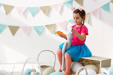 Paskalya oynarken küçük kız oturma odası dekore edilmiştir.