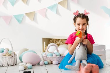 Paskalya oynarken küçük kız oturma odası dekore edilmiştir.