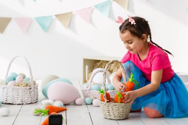 Paskalya oynarken küçük kız oturma odası dekore edilmiştir.