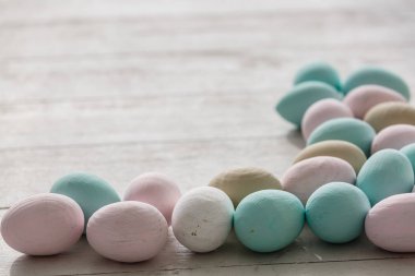 Paskalya yumurta beyaz ahşap plakalar üzerinde pastel renklerde yığını
