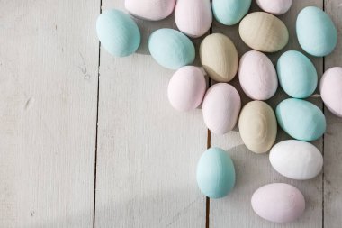 Paskalya yumurtaları hafif ahşap plakalar üzerinde pastel renklerde yığını