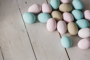 Paskalya yumurtaları hafif ahşap plakalar üzerinde pastel renklerde yığını