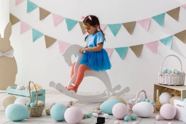 Paskalya oynarken küçük kız oturma odası dekore edilmiştir.