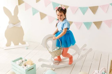 Paskalya oynarken küçük neşeli kız oturma odası dekore edilmiştir.