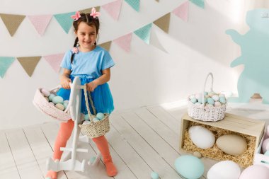 Paskalya oynarken küçük neşeli kız oturma odası dekore edilmiştir.