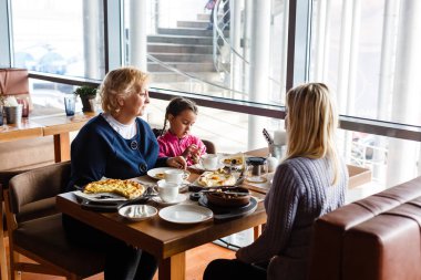 Aile kafede kahvaltı yapıyor.