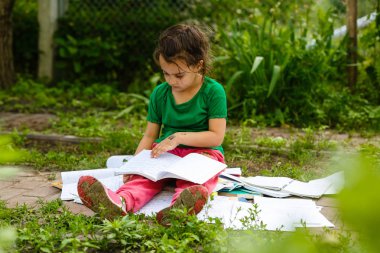 küçük kız çim yeşil bahar Park üzerinde ödev