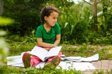 küçük kız çim yeşil bahar Park üzerinde ödev