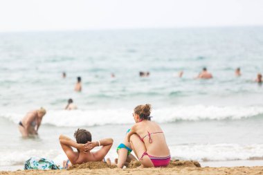 İnsanlar sahilde dinleniyor.