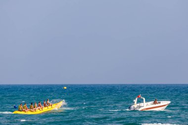 İnsanlar gündüz vakti denizde eğleniyor. 