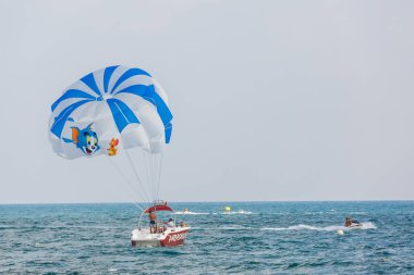 Kalabalık denizde paraşütle kayık 